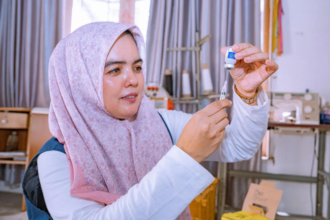 Marlina, immunization coordinator and vaccinator, prepares vaccines in Padang Tiji Community Health Centre (Puskesmas) located in Pidie District, Aceh Province, Indonesia. 