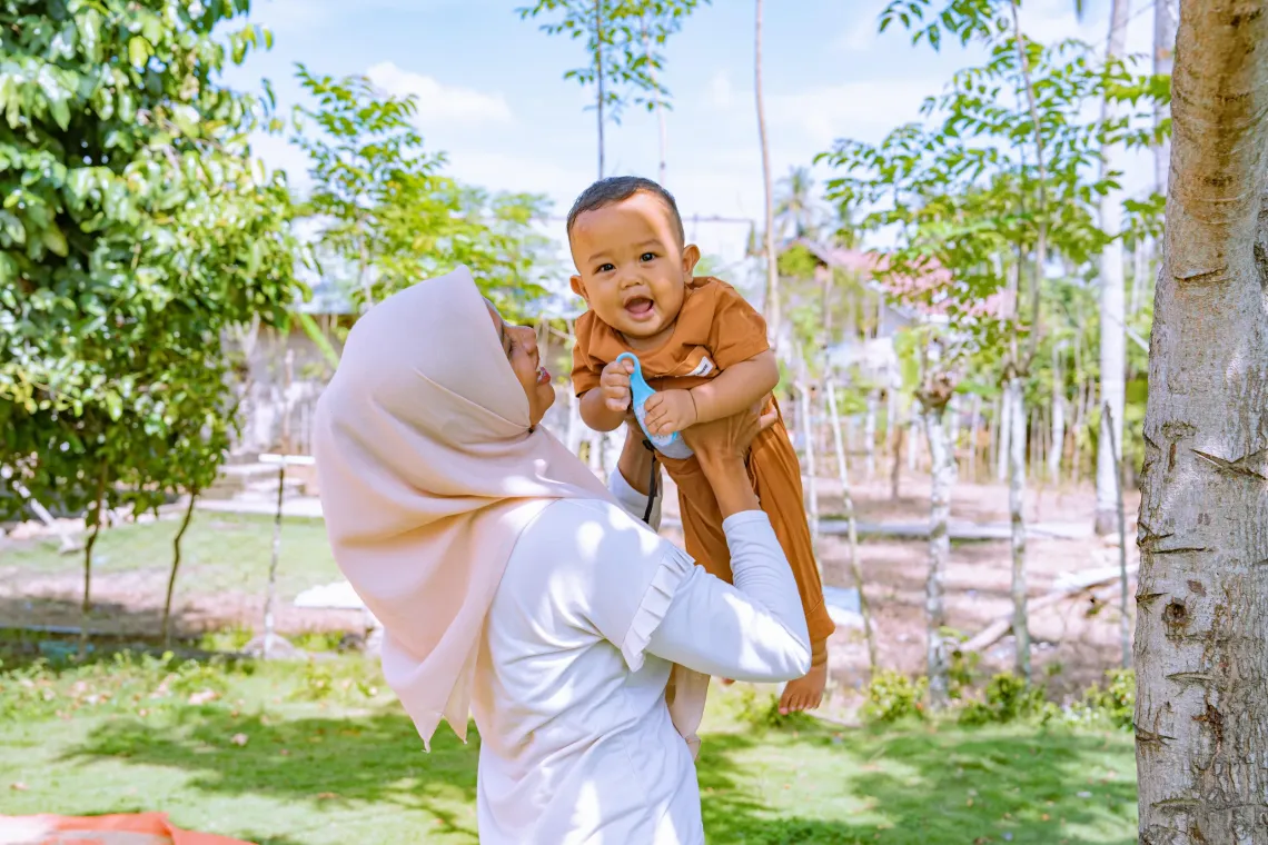 Dahniar plays with her nine-month-old Shaquel outside their home in Pidie District, Aceh Province, Indonesia. 