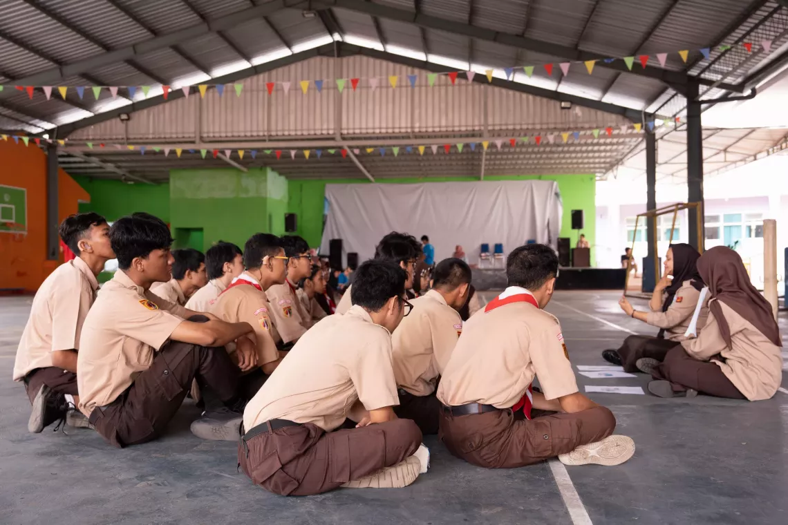 Siswa SLB Negeri Semarang mendengarkan sesi tentang keamanan daring yang dipimpin oleh Shelda, 18, dan Caca, 16, di halaman sekolah.