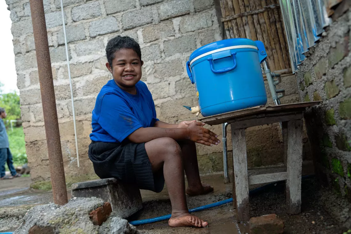 Febriari Uba Sisa, 14, a person with disability, washes her hand near the bathroom in her house in Larantuka Island, East Nusa Tenggara. 