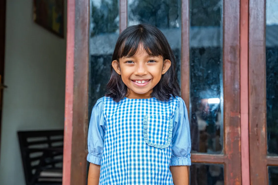 Melvi, 7, in front of her home in the Kupang Municipality, East Nusa Tenggara, on 12 December 2025 