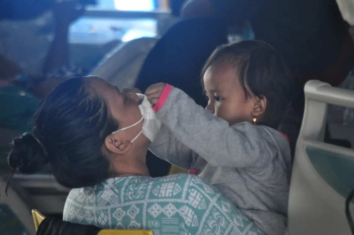 On 17 January 2021, a child puts a mask on her mother in a medical tent in Mamuju Regency, West Sulawesi, Indonesia.