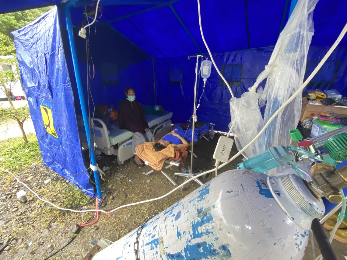 Suwinda, 23, receives medical treatment in a tent in Mamuju Regency, West Sulawesi Province, Indonesia, on 17 January 2021. Suwinda lost her baby daughter after she was unable to receive medical care as she gave birth during an earthquake that struck the Indonesian island of Sulawesi on 15 January 2020.