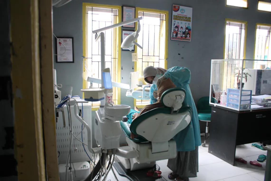 Dental therapist Rindima tends to a patient at Puskesmas Binanga.