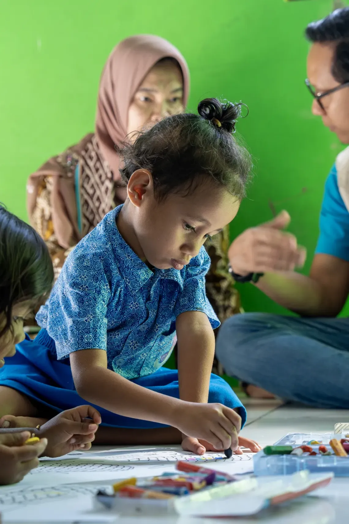 Lani, age six, colours in her book at Harapan Bangsa Early Childhood Development (ECD) Centre. Kupang District, East Nusa Tenggara Province, Indonesia. 