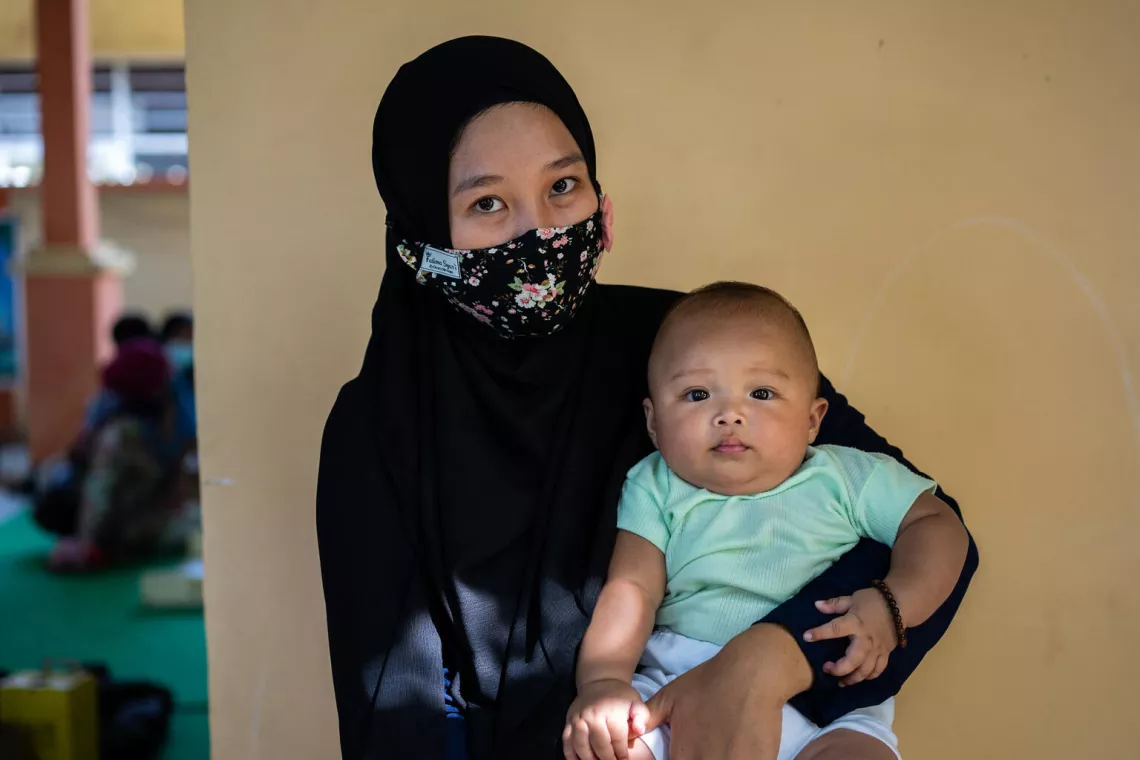 Fitria holds her son