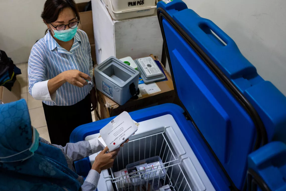 Nurse Desak brings the vaccine in a cold box