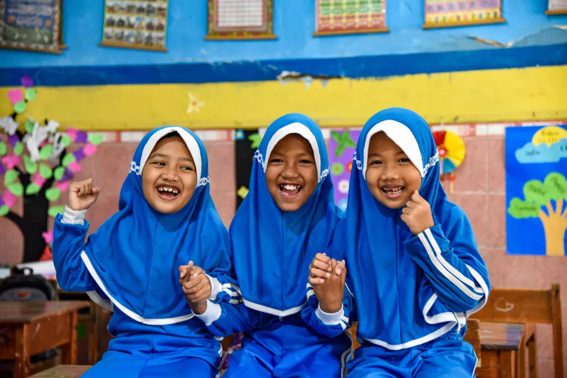 Rere (centre) age 11, Anindita (left) age 7 and Gauri (right) age 7, sit inside their class at Muhammadiyah Islamic Elementary School in Rembang, Purbalingga.  