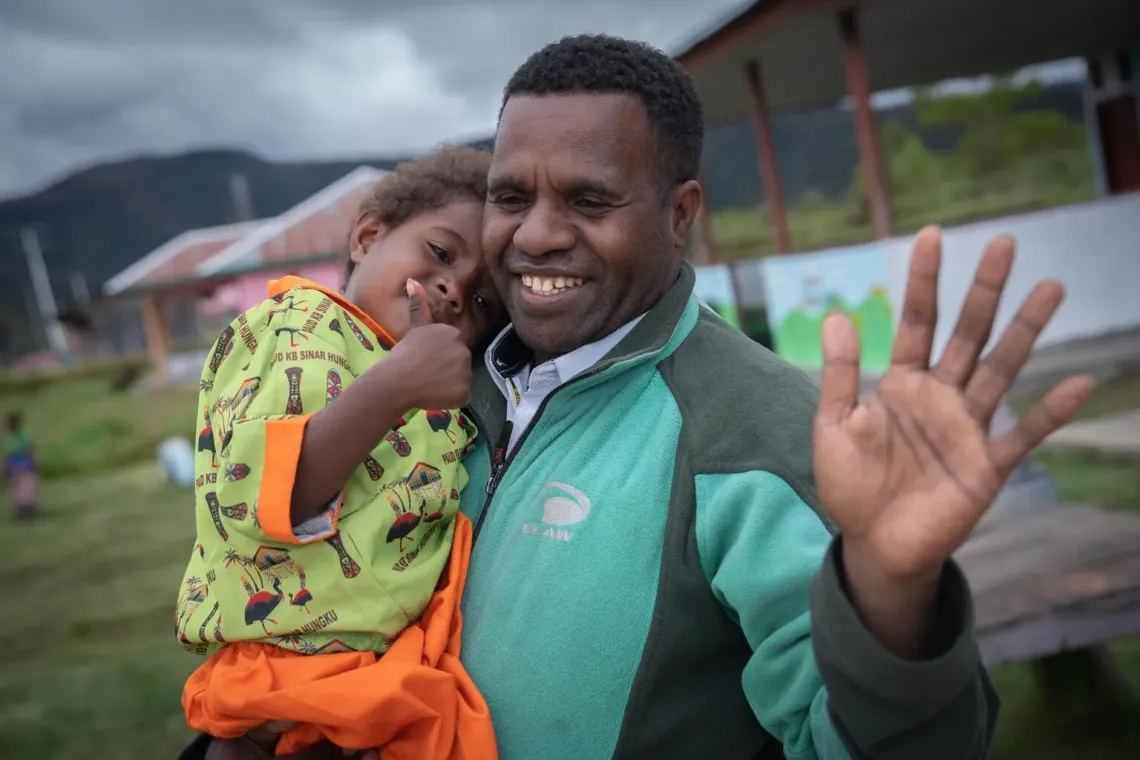 David and his daughter, Kerenzia, 3, in front of the school courtyard at Sinar Hungku Early Child Education Centre, Arfak Mountains, Papua, on 14 August 2025.