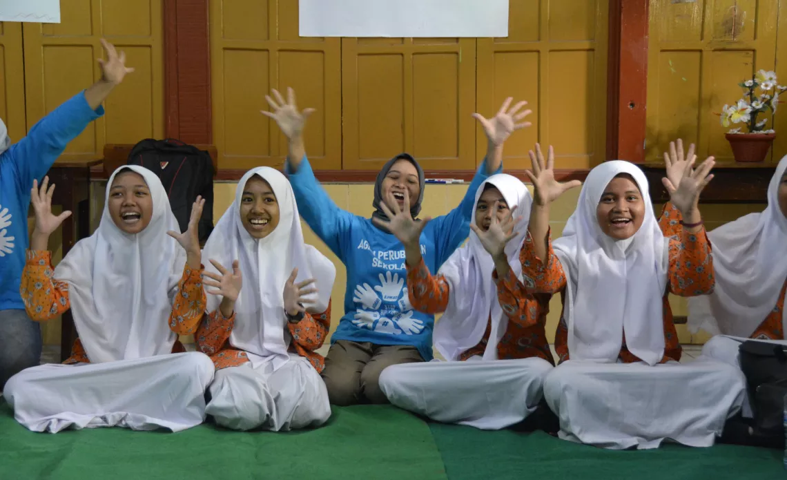 Anak-anak dan fasilitator mereka membawakan yel di awal kelas anti--perundungan 