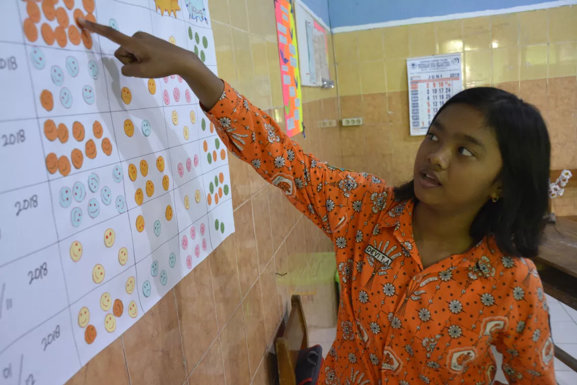Deri, 15, points to a &lsquo;wall of feelings&rsquo; that shows students&rsquo; emotions at the start of each session