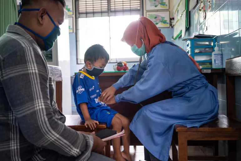 A nurse wears a mask when treating a patient in Puskesmas Bayat, Klaten, Central Java