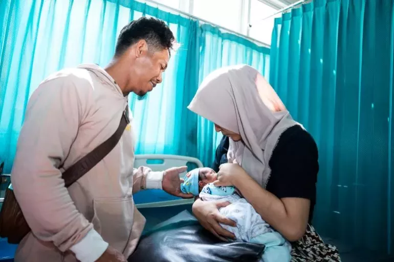 Mardiana, a mother who has just given birth at the Sakra Health Center, with her husband, Khairul, and Rihana, their 11-day-old baby, at the Sakra Health Center, East Lombok, West Nusa Tenggara