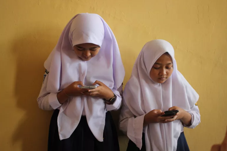 Two girls looking on their phones