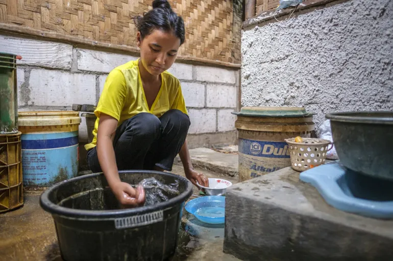 A mother washes dishes