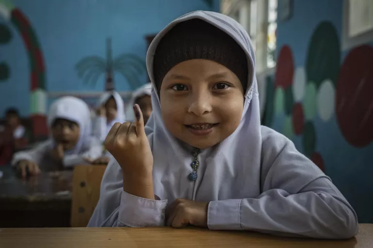 A girl shows her inked finger