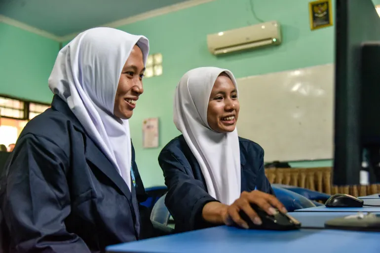 Two students work on a computer together