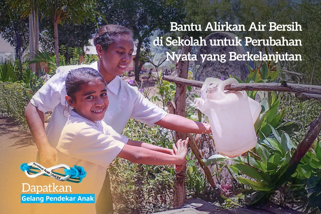 A girl washes her hands with the help of her teacher
