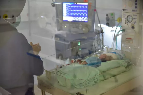 A healthworker with a baby in NICU