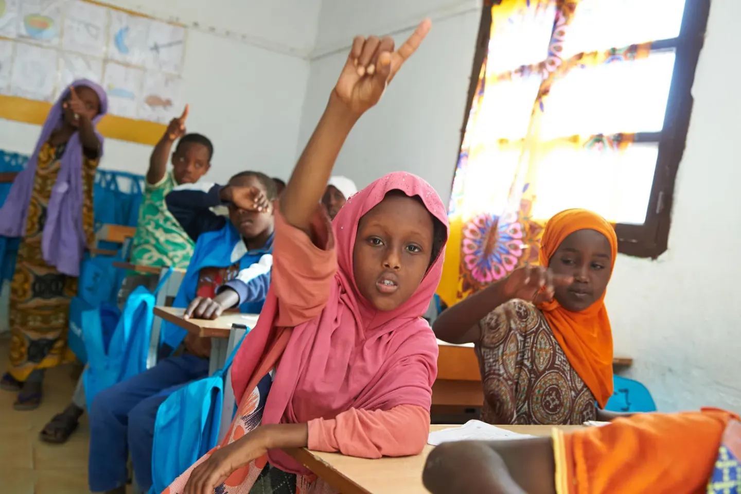 Children raising their hands in a classroom in Djibouti
