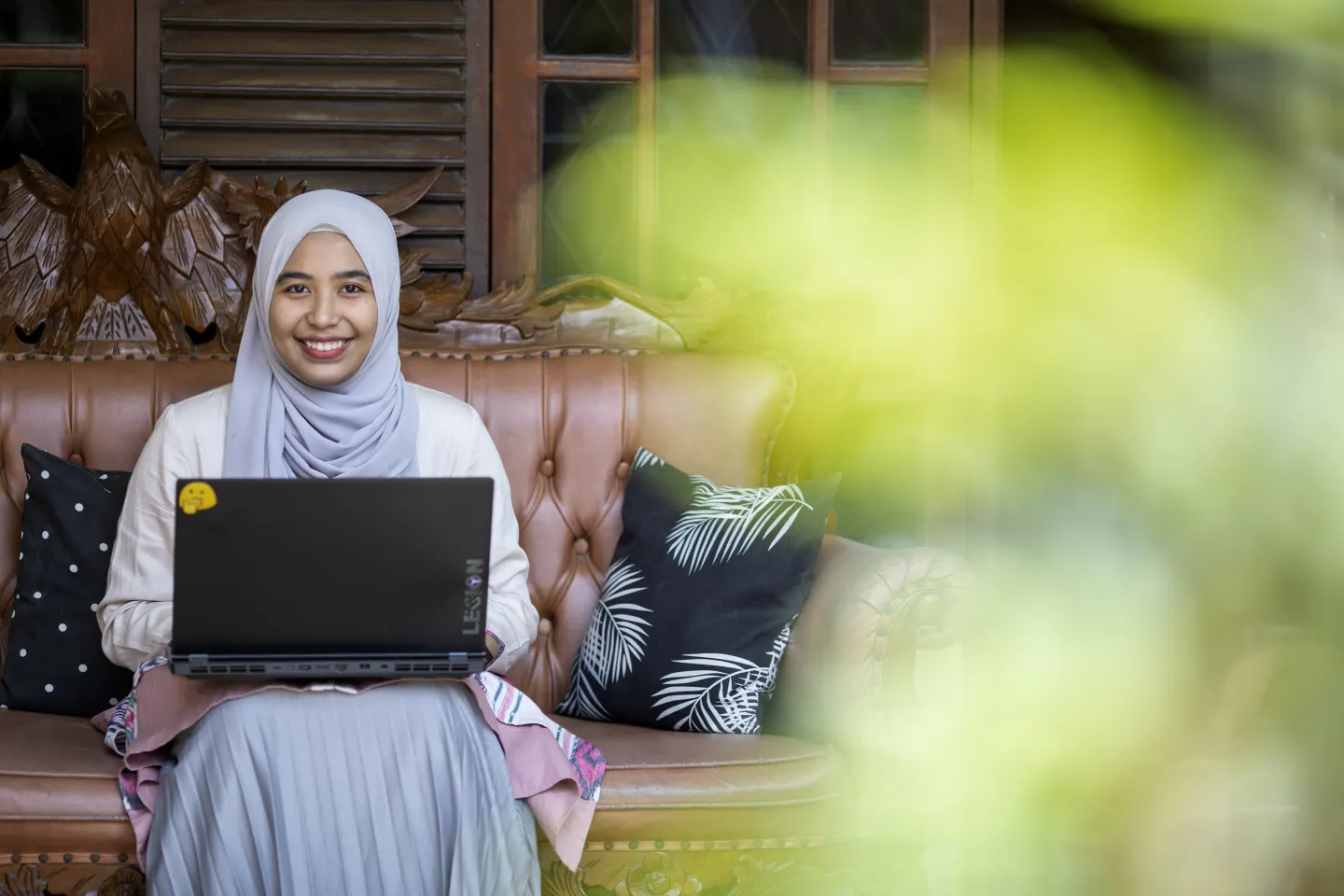 University student sits with her laptop at her home in Bogor, Indonesia