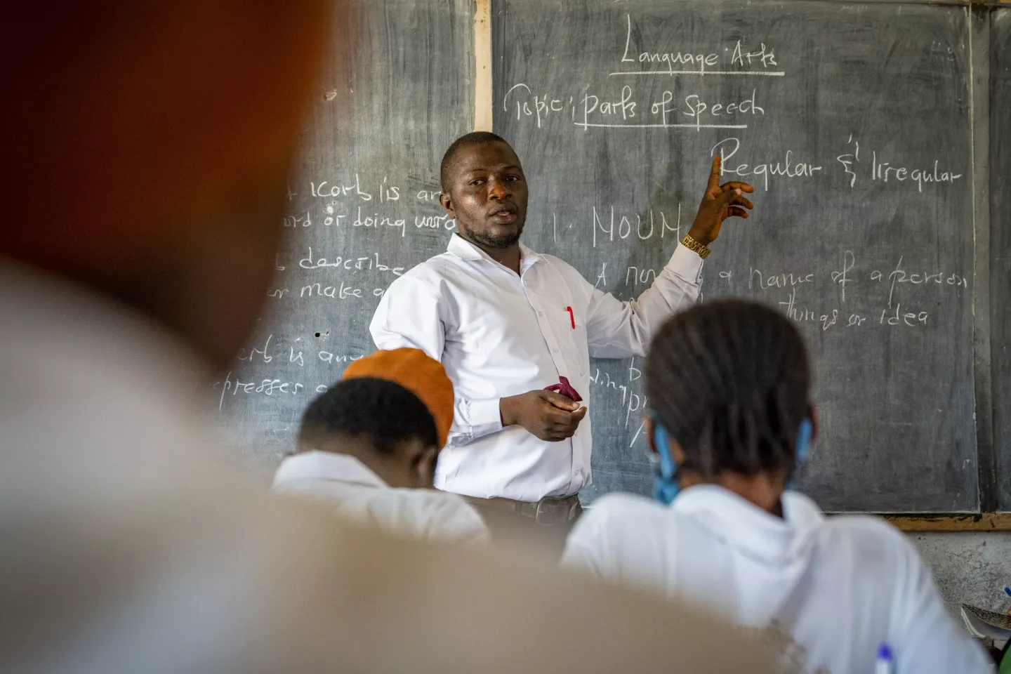 A teacher in Sierra Leone points to the blackboard in his classroom