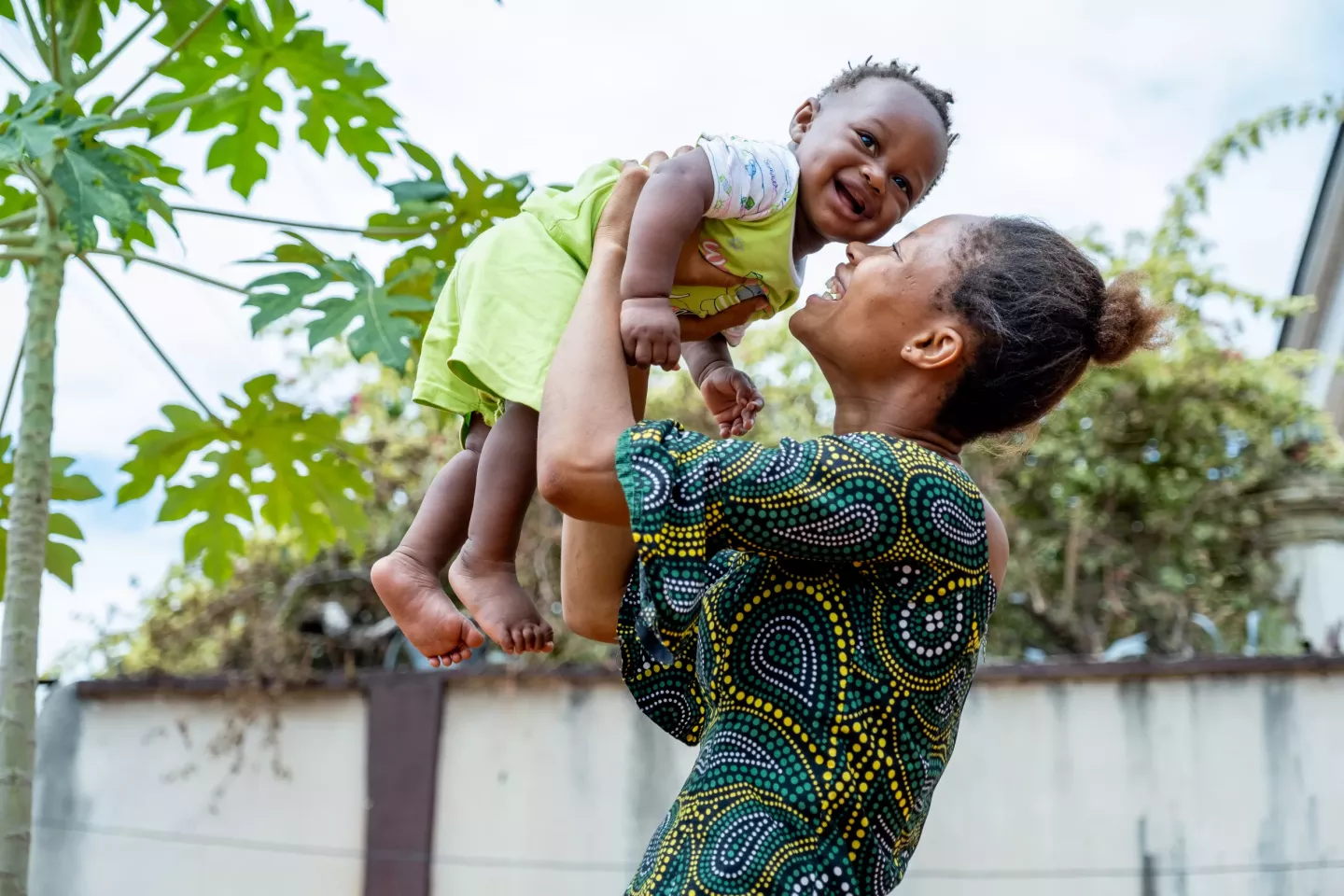 A woman holding her young child in the air
