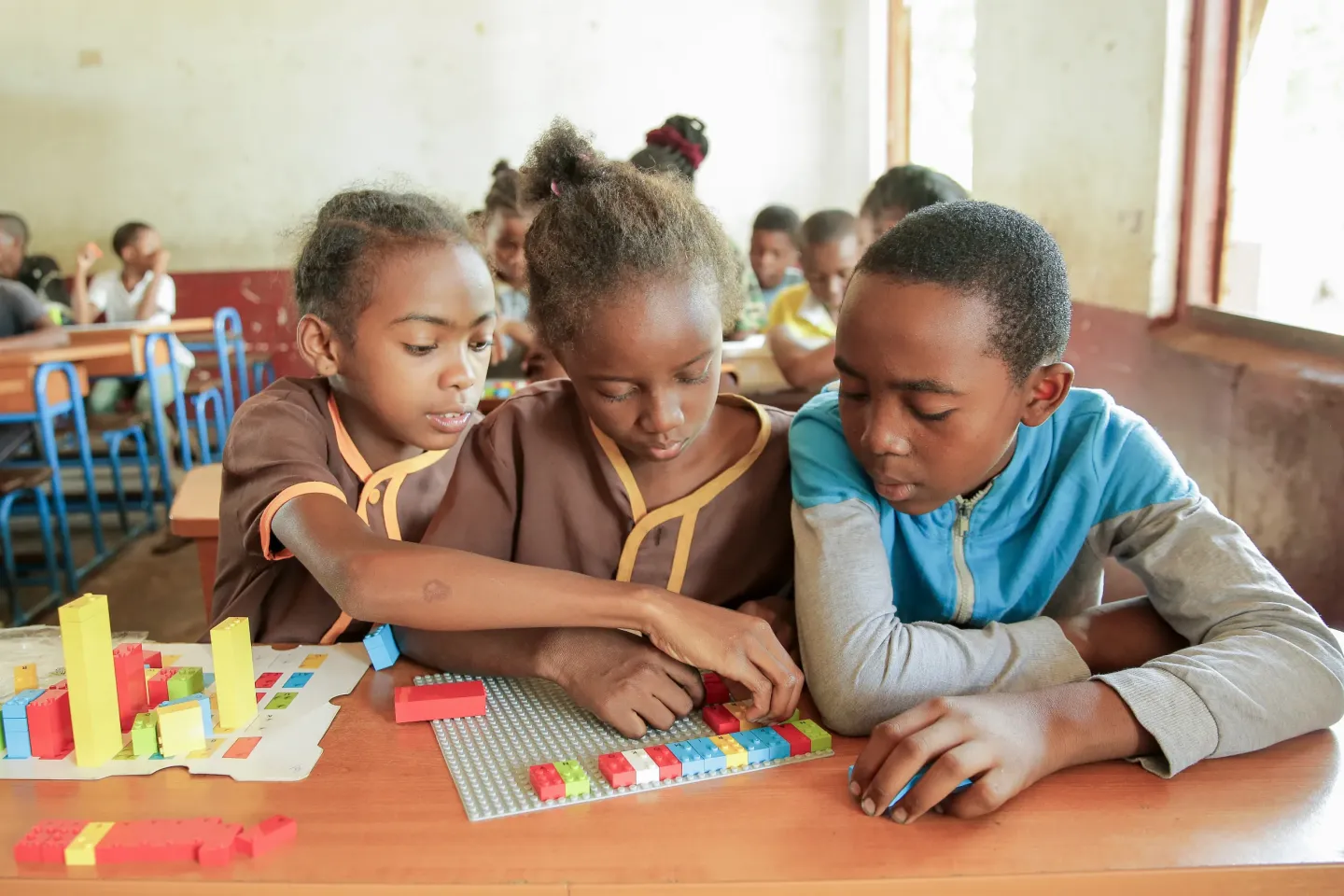 Three children playing with blocks at a school in Madagascar