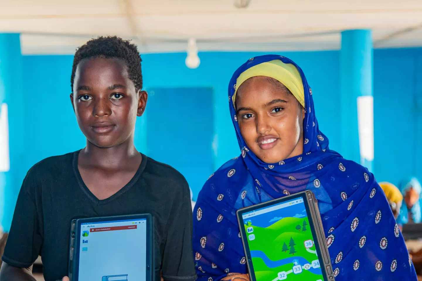 Two children at school in Mauritania hold up their devices