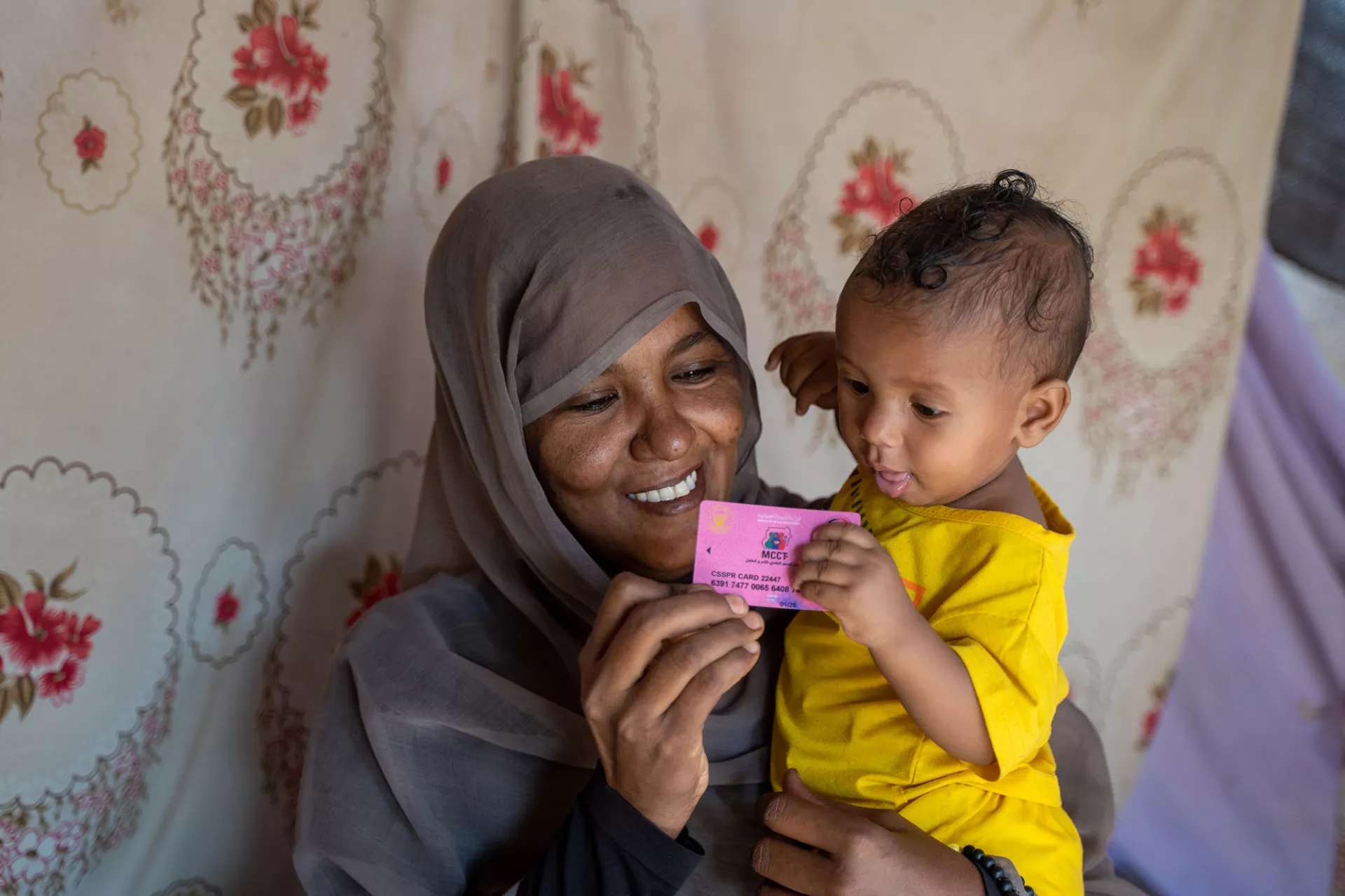 A woman and a young child hold a registration card