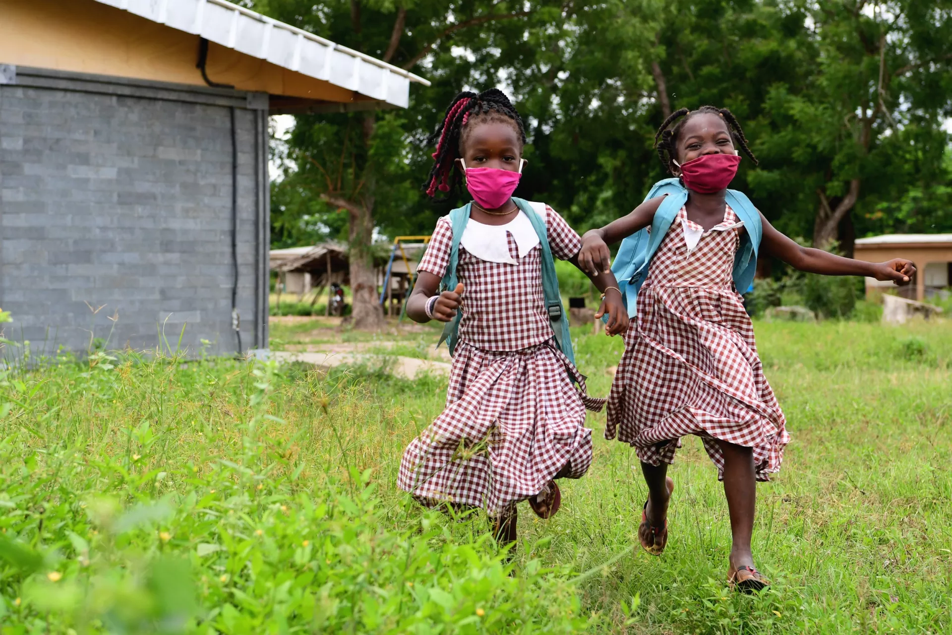 Two girls wearing protective face masks