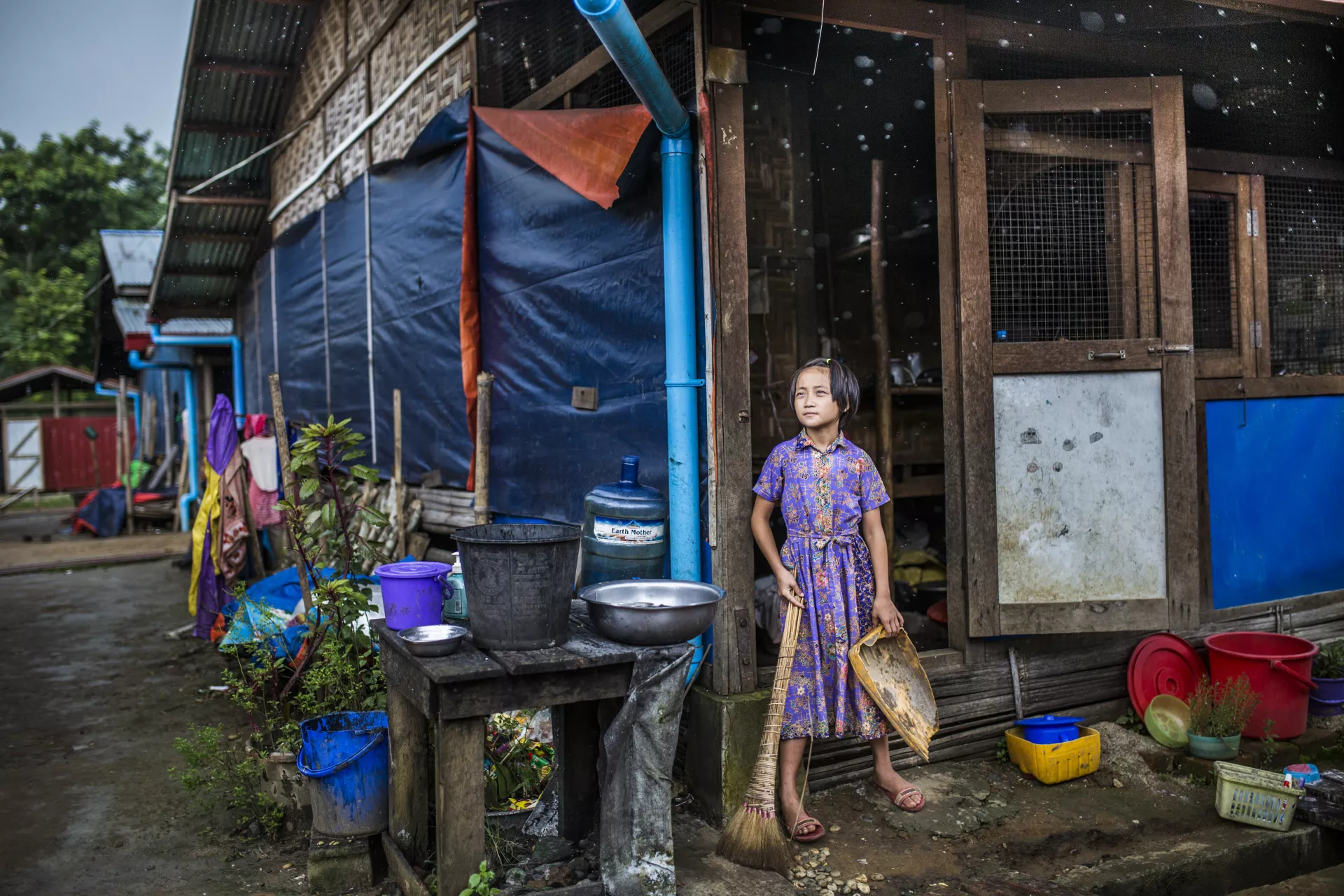 Girl standing in the entraceway of her home at Pa La Na IDP camp on the outskirts of Myitkyina, Kachin, Myanmar