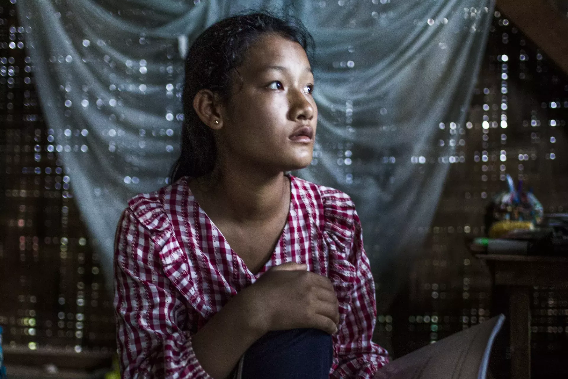 An adolescent girl pictured inside her family&rsquo;s shelter, Myanmar