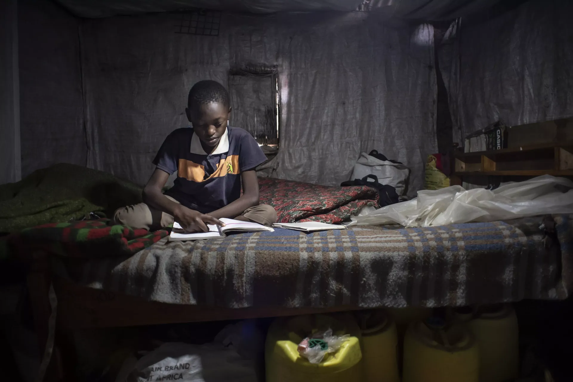 An 11-year-old studying while sitting on a bed