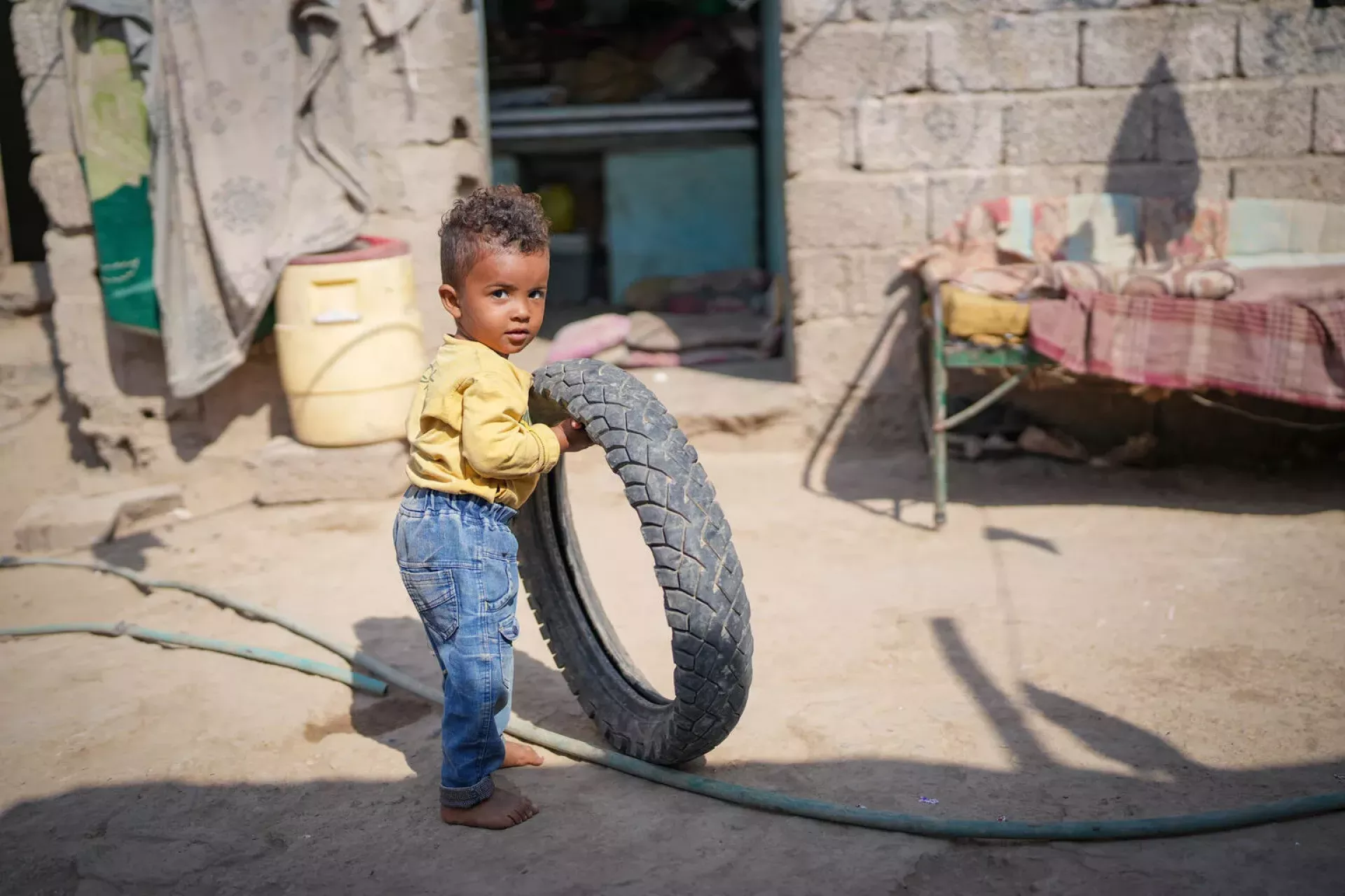 Young boy playing with a bicycle tyre