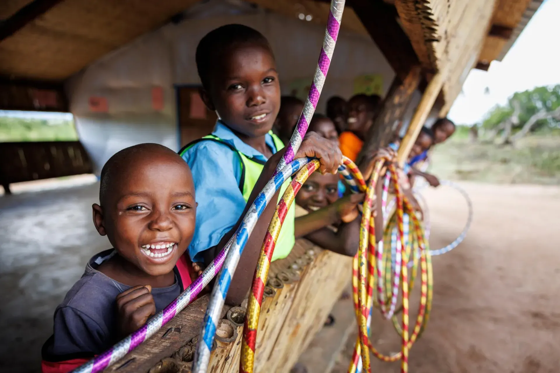 A group of kids holding multicolored hula hoop