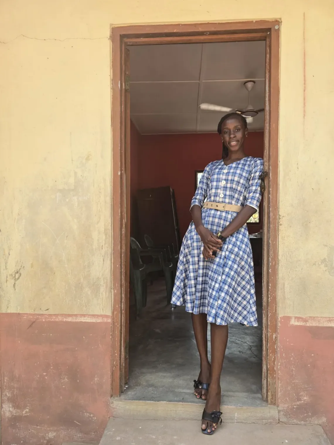 Head Teacher Thelma poses in the doorway of a classroom while conducting daily rounds around her school in Ghana.