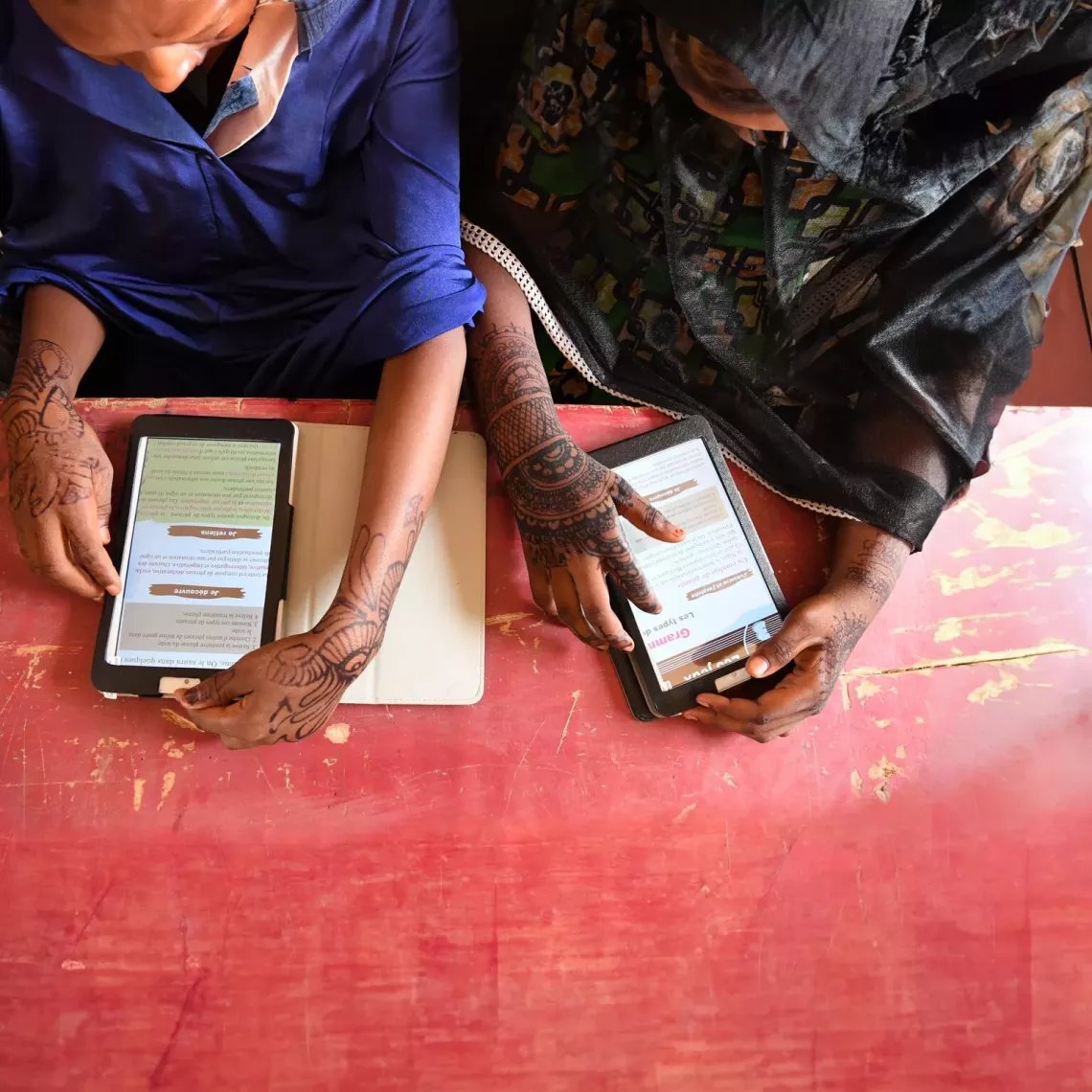 Overhead view of children using electronic tablets