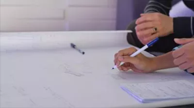 hand with a pen writing on a paper 