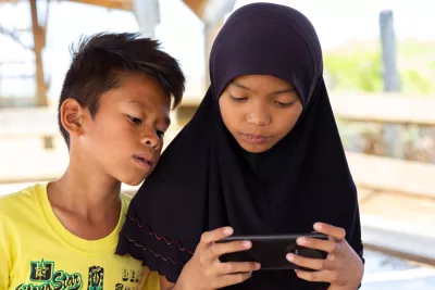 Jalaisa, 12, and her brother Jarrer, 13, look at a phone in the tented evacuation site where they currently live with their family, on the outskirts of the city of Marawi, Province of Lanao Del Sur, Bangsamoro Autonomous Region in Muslim Mindanao (BARMM), Philippines.