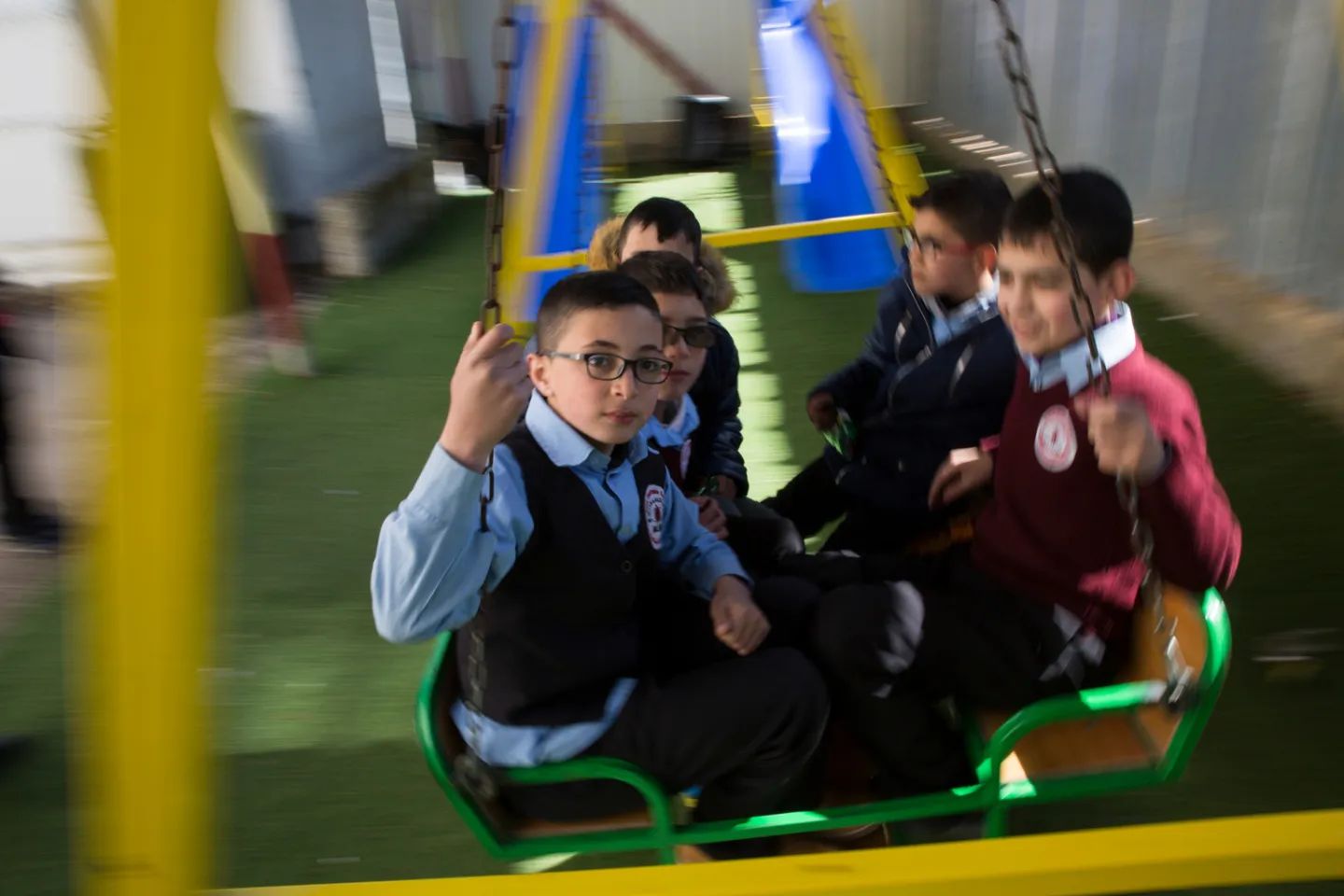 Children sitting down on a swing