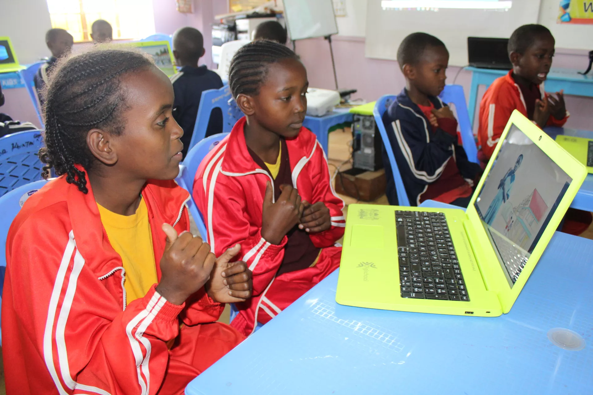 Primary students in Kenya practice sign language with the universal textbook project.