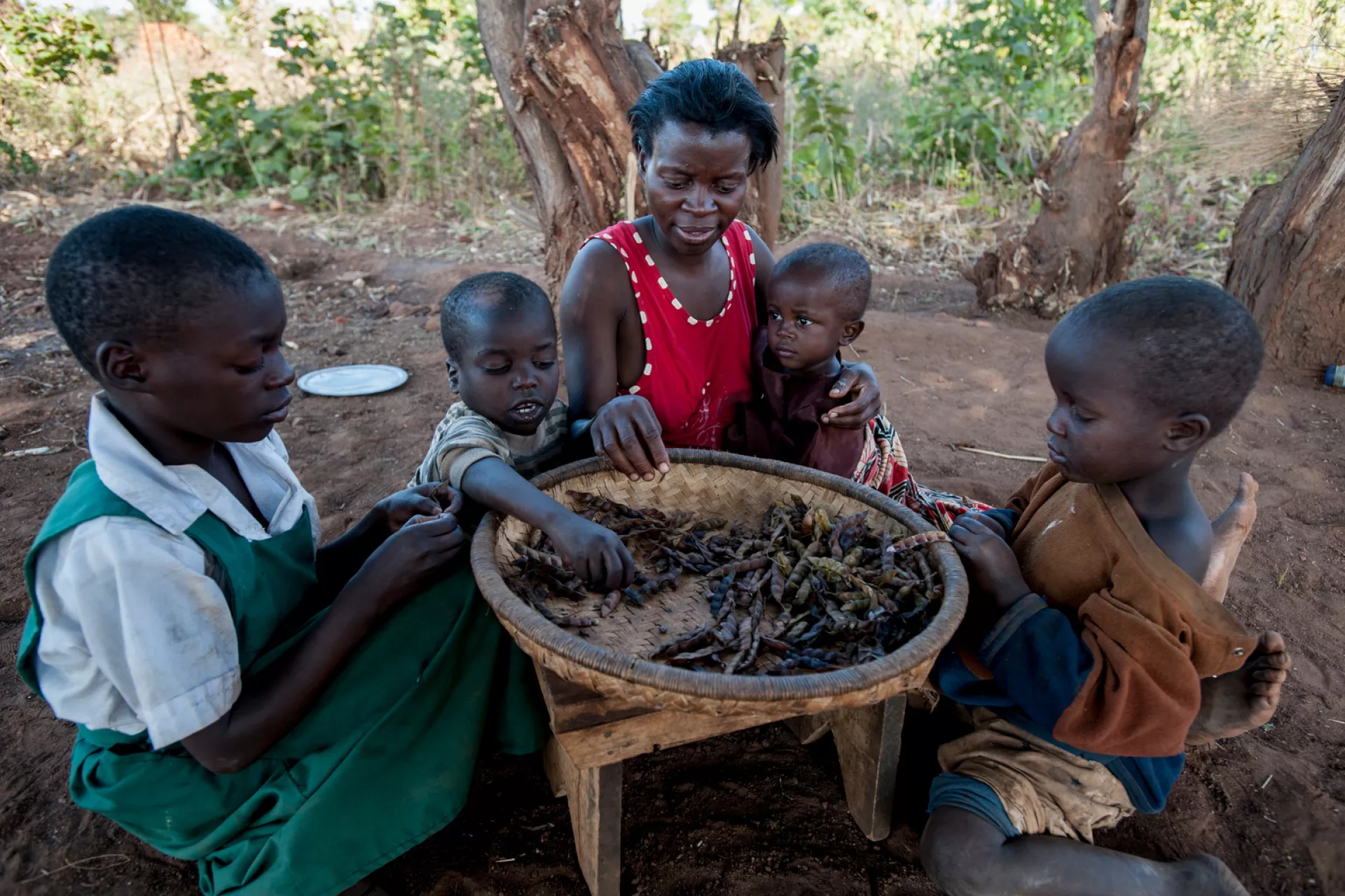 A family eats a daily meal of dried peas at home in Balaka district in Malawi.