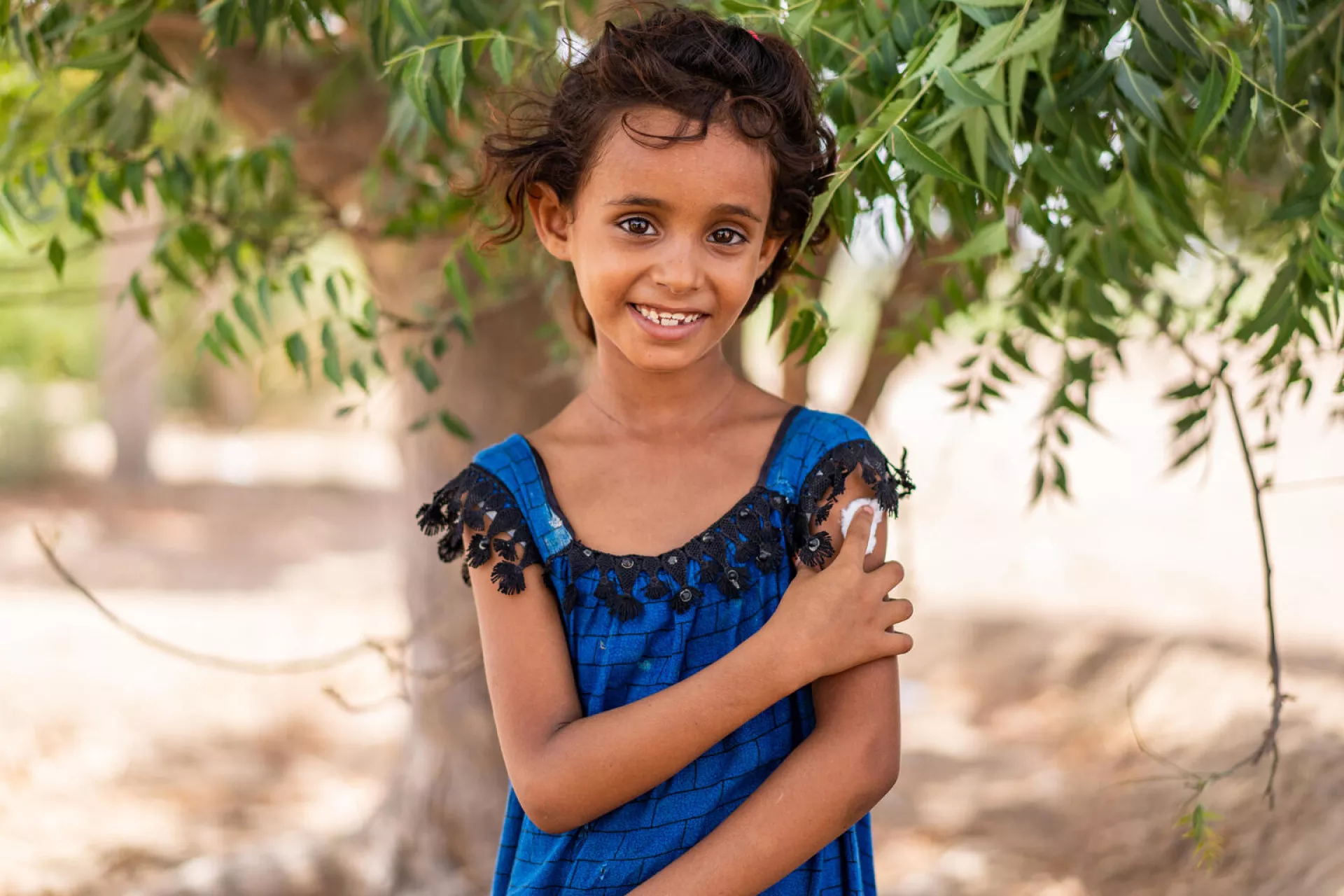 On 6 June 2022 in Aden Governorate, Yemen, 7-year-old Hind Ali Nasser holds her arm after being vaccinated.