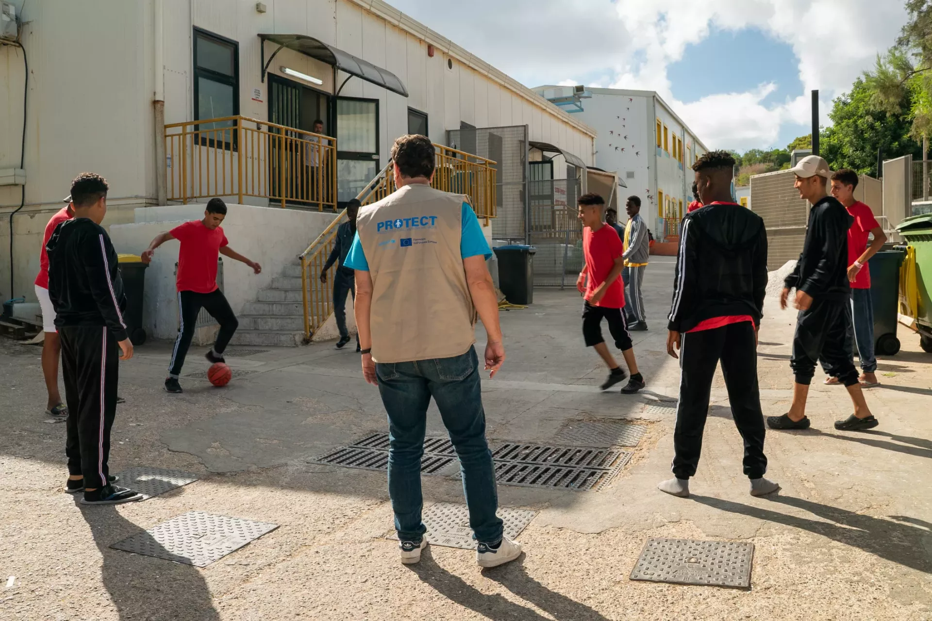 young people play soccer with UNICEF staff