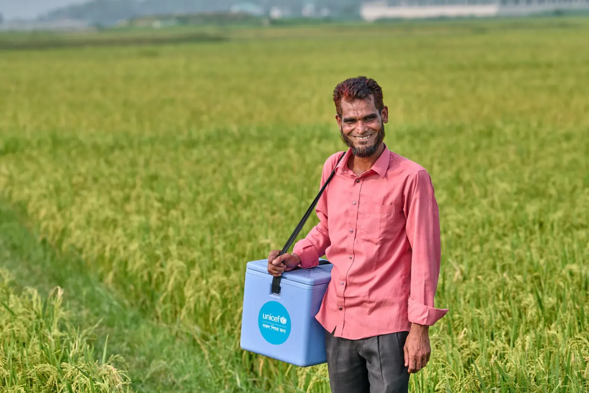 Vaccinator Abdul Baten with a vaccine carrier on his shoulder
