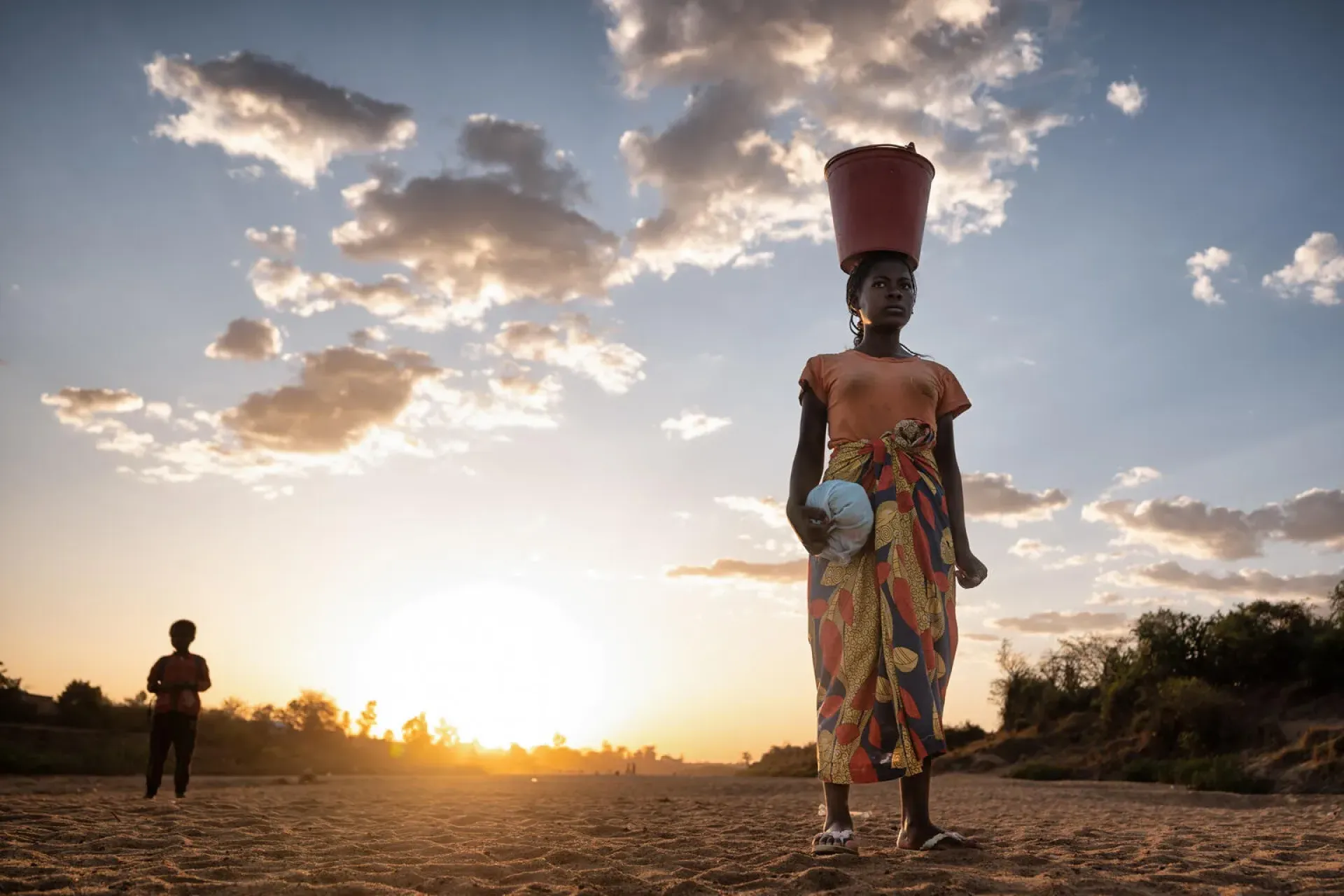 The photo shows a woman standing on the dry Menarandra riverbed