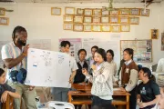 man holding up a poster in a classroom