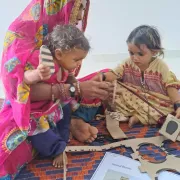 Mother with children playing with toys in Pakistan