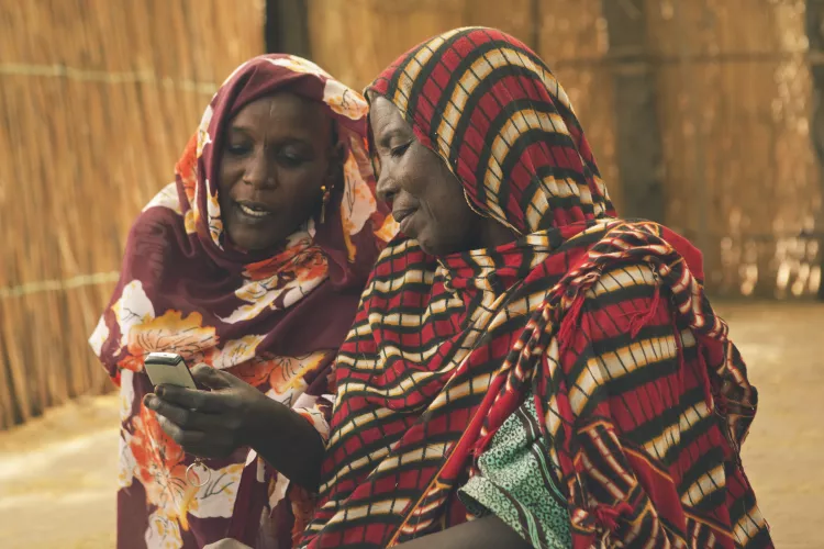 Two adults looking at mobile sending real time info 